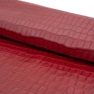 May include: Red faux leather with a crocodile embossed pattern.