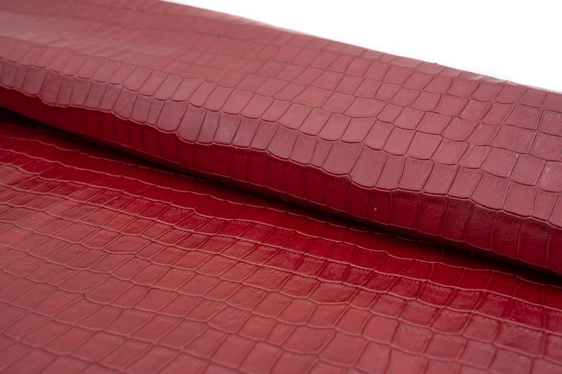 May include: Red faux leather with a crocodile embossed pattern.