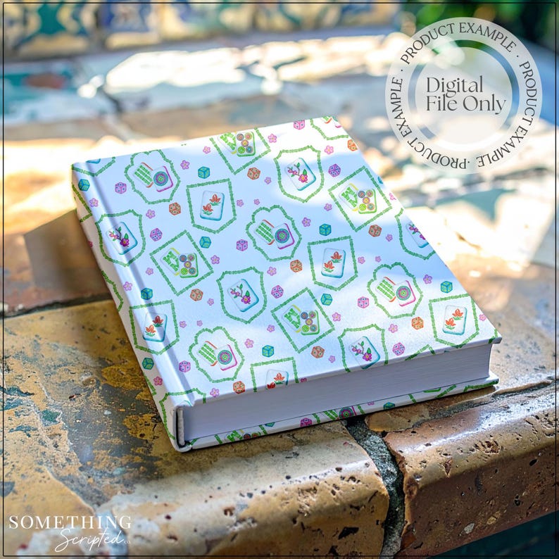 May include: A hardcover notebook with a white cover featuring a repeating pattern of green, orange, and purple floral and geometric designs. The text "Digital File Only" is visible on the cover. The notebook is resting on a stone surface.
