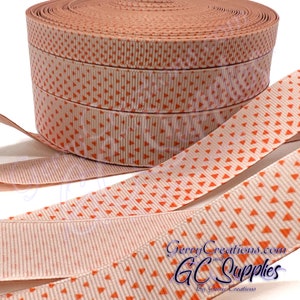 May include: A roll of off-white grosgrain ribbon with a repeating pattern of small orange triangles. The ribbon is 1.5 inches wide and is available in various lengths.
