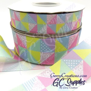 May include: Two spools of pastel colored ribbon with a patchwork design. The ribbon features a variety of pastel colors including pink, blue, yellow, and green. The ribbon has a white polka dot pattern on some of the squares. The ribbon is 2.5 inches wide.