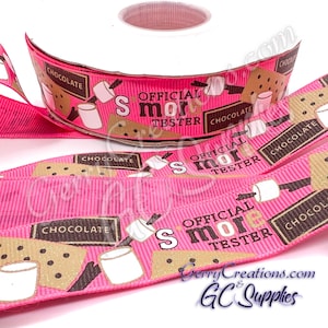 May include: A roll of pink ribbon with a repeating pattern of s'mores, marshmallows, chocolate bars, and the text "Official S'more Tester." The ribbon is ideal for crafting and gift wrapping.