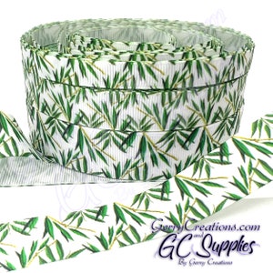 May include: A roll of white grosgrain ribbon with a green bamboo leaf print. The ribbon is 1.5 inches wide and is perfect for crafting, decorating, and gift wrapping.