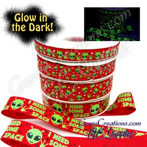 May include: Red and green glow-in-the-dark ribbon with alien faces and the text "I need some space".