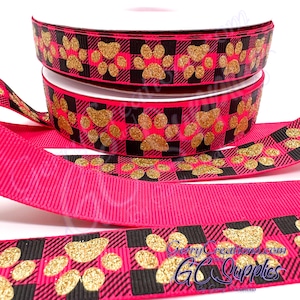 May include: Pink and black plaid ribbon with gold glitter paw prints. The ribbon is 2.5 inches wide and is perfect for crafting, decorating, and gift wrapping.