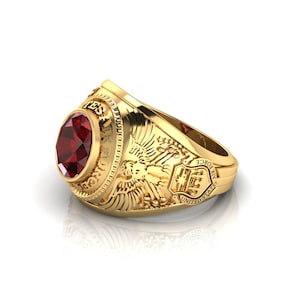 Op de afbeelding: Een gouden ring met een rode edelsteen en de inscriptie "United States Air Force".