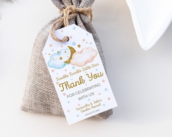 May include: A small burlap bag with a thank you tag attached. The tag has a blue and pink cloud design with gold stars and the text "Twinkle Twinkle Little Star Thank You For Celebrating With Us Samantha & John's Gender Reveal August 17, 2020".
