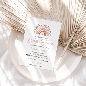 May include: A baby shower invitation with a pink and brown rainbow illustration. The text reads "Please join us for a Baby Shower honoring the mommy-to-be Semantha Thompson Saturday, October 14 at 2:00 in the afternoon 1800 Rainbow Lane, Los Angeles, CA RSVP and details - Katie at 555-5555 registered at AMAZON.COM & TARGET"