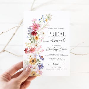 Bridal shower invitation with colorful wildflowers arch and cursive writing. The invite includes watercolor illustration of soft summer wildflowers in pink, yellow, blue, purple, red and white tones. The text includes bridal brunch as it's title.