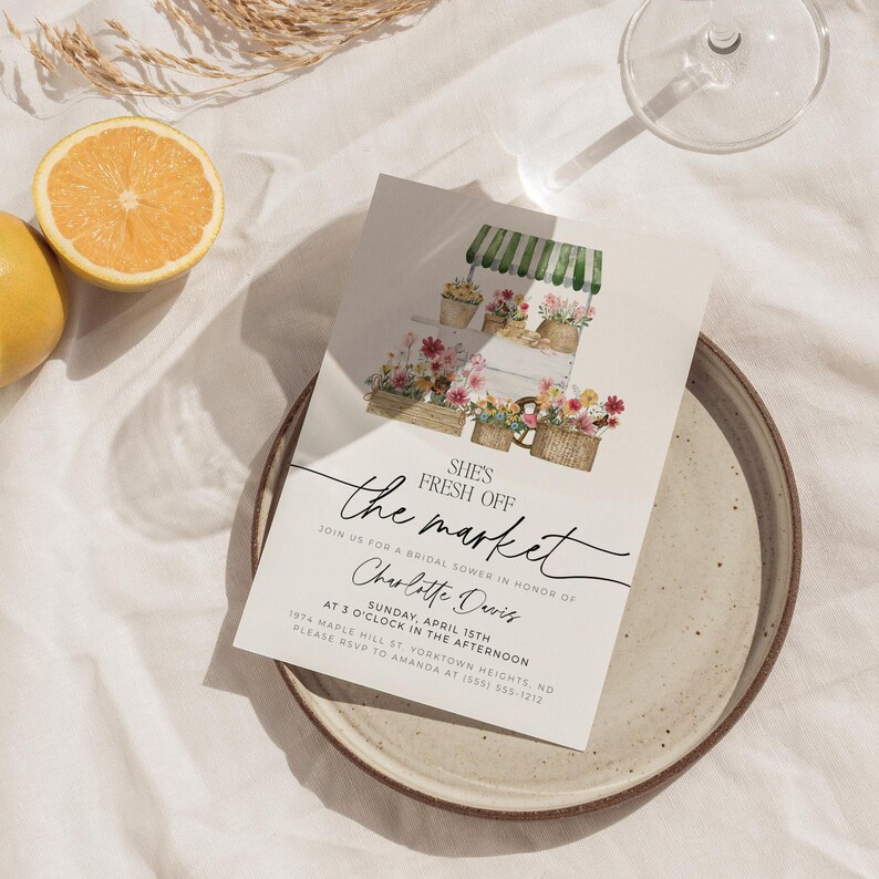 Pu&ograve; includere: Un invito per un addio al nubilato con un'illustrazione ad acquerello di una bancarella del mercato dei fiori. L'invito presenta il testo "She's Fresh Off the Market" e i dettagli dell'evento, incluso il nome Charlotte Davis.