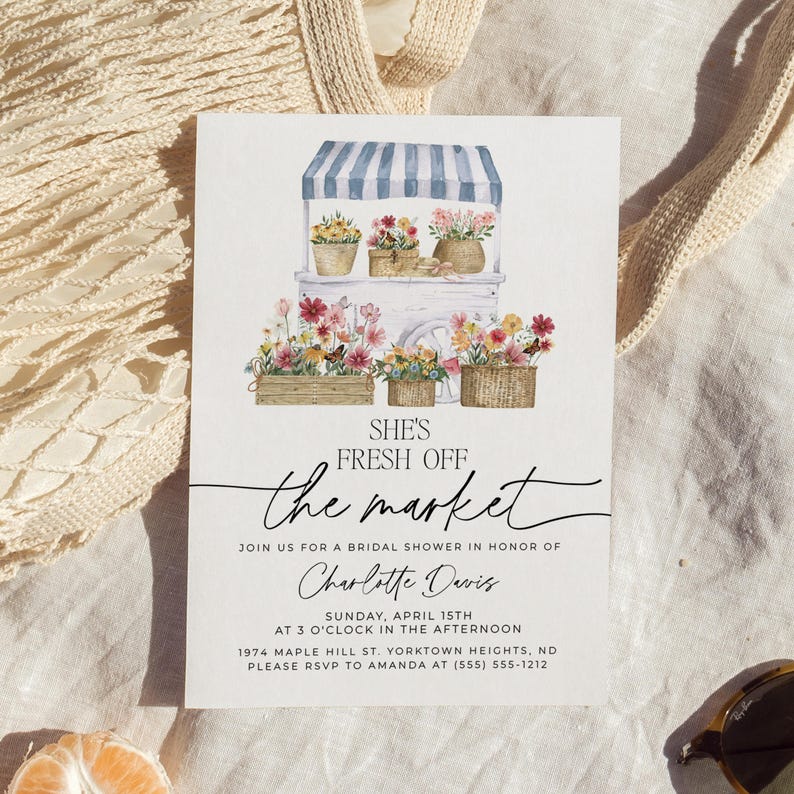 Op de afbeelding: Een aquarel-illustratie van een bloemenkar met een blauw-wit gestreept luifel. De tekst "She's Fresh Off the Market" is geschreven in zwarte cursieve letters. De uitnodiging is voor een bruidsdouche voor Charlotte Davis op zondag 15 april om 15:00 uur. Het adres is 1974 Maple Hill St. Yorktown Heights, ND. De RSVP-informatie is voor Amanda op (555) 555-1212.