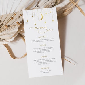 May include: A white menu card with a gold crescent moon and stars design. The menu features appetizers, salad, entree, and dessert options. The text on the menu is in gold.