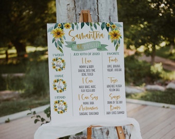 May include: A white poster with a sunflower design and the text "Samantha My 1st Birthday July 10th of 2020". The poster lists information about Samantha's first birthday, including her weight, number of teeth, height, favorite foods, toys, songs, and books.