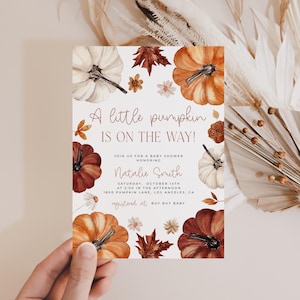 Pumpkin baby shower invitation with orange, copper and white pumpkin and autumn florals and leaves that is handheld.