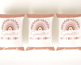 Può includere: Tre sacchetti regalo bianchi con un design arcobaleno rosa e marrone e il testo "Samantha's First Birthday!" stampato su ogni sacchetto.