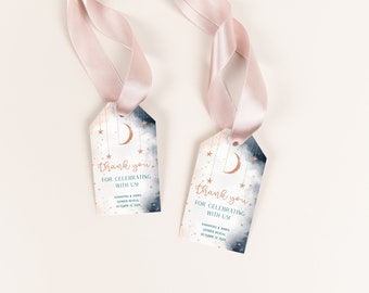 May include: Two blue and white thank you tags with a gold crescent moon and stars hanging from it. The text on the tag reads "Thank you for celebrating with us" with the names Samantha & John's Gender Reveal and the date October 12, 2020.