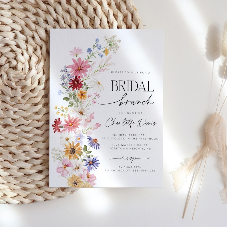 Bridal shower invitation with colorful wildflowers arch and cursive writing. The invite includes watercolor illustration of soft summer wildflowers in pink, yellow, blue, purple, red and white tones. The text includes bridal brunch as it's title.