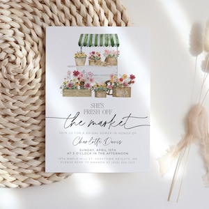 Pu&ograve; includere: Un invito per un addio al nubilato con un'illustrazione ad acquerello di un banco di fiori. L'invito recita "She's Fresh Off the Market" con i dettagli dell'evento. Il design presenta composizioni floreali e le informazioni dell'evento.
