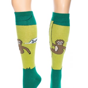 May include: Green and yellow knee-high socks with a sloth graphic and the text "Super Sloth".