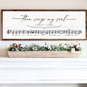 May include: A white wooden sign with the text "Then sings my soul" and "How great thou art."  The sign also features musical notes and a green floral design.