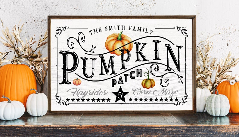May include: A white wooden sign with black text that reads "The Smith Family Pumpkin Patch Hayrides $5 Corn Maze". The sign has a brown wooden frame and is decorated with fall-themed illustrations, including pumpkins and vines.