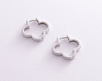May include: A pair of silver-toned hoop earrings, each featuring a four-leaf clover or flower-shaped outline. The earrings have a polished metallic finish and a hinged closure mechanism, designed as open-frame shapes with smooth edges.