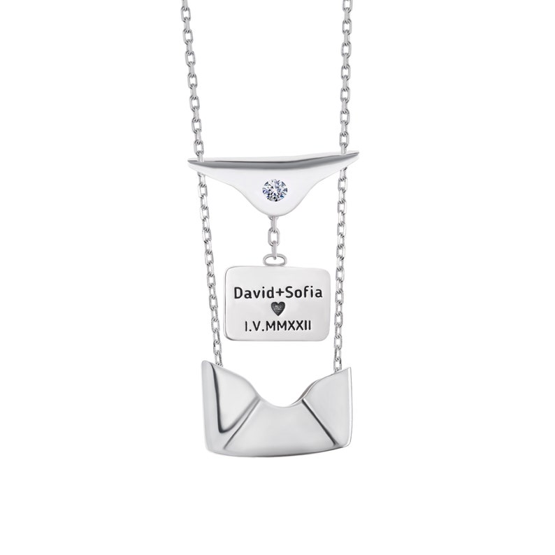 May include: Silver necklace with a small diamond and a pendant that says "David+Sofia I.V.MMXXII" with a heart symbol.