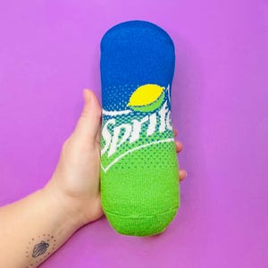 May include: A green and blue sock shaped like a Sprite can with the word "Sprite" printed on it.