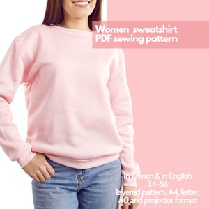May include: A pink sweatshirt sewing pattern in PDF format. The pattern is available in French and English and includes sizes 34-56. The pattern is layered and comes in A4, letter, AO, and projector formats.