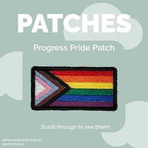 Puede incluir: Un parche rectangular del Orgullo Progresista con un diseño de arcoíris y colores adicionales que representan a la comunidad transgénero, las personas de color y las personas que viven con o han fallecido a causa del SIDA. El parche tiene un borde negro y la palabra "PATCHES" en blanco.