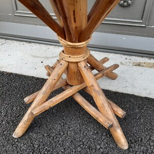 Puede incluir: Una base de mesa de madera con un centro de bamb&uacute; tejido y cuatro patas conectadas por vigas transversales.
