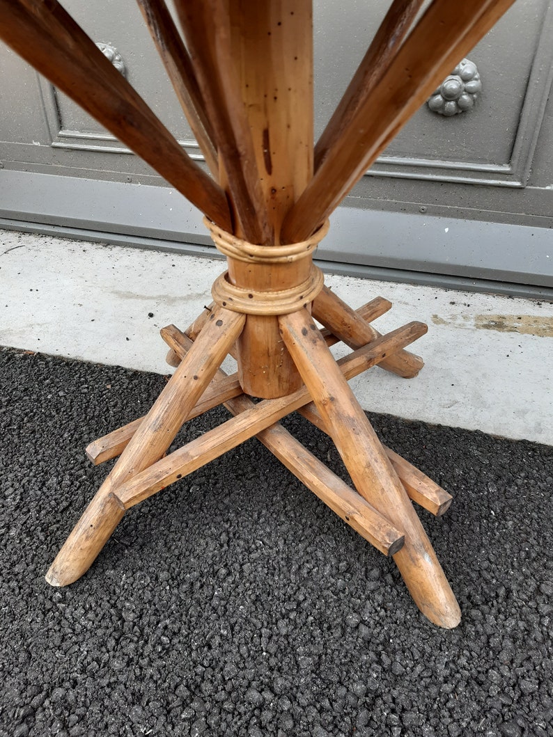 Puede incluir: Una base de mesa de madera con un centro de bamb&uacute; tejido y cuatro patas conectadas por vigas transversales.