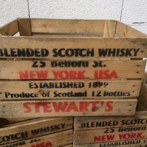 May include: A vintage wooden crate with the text "BLENDED SCOTCH WHISKY 23 Benora St. NEW YORK, USA ESTABLISHED 1899 Produce of Scotland 12 bottles STEWART'S" printed on the front.