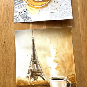 K&ouml;nnte beinhalten: Ein Aquarellbild eines Croissants, einer Tasse Kaffee und des Eiffelturms auf braunem Hintergrund. Das Bild ist im Kaffeefleckenstil gehalten.