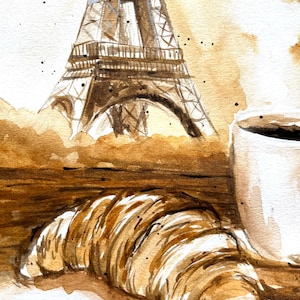 K&ouml;nnte beinhalten: Ein Aquarellbild eines Croissants, einer Tasse Kaffee und dem Eiffelturm im Hintergrund. Das Bild ist in Braun- und Wei&szlig;t&ouml;nen gehalten.