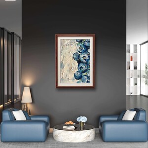 May include: A framed abstract painting with a brown wooden frame. The artwork features textured white and blue brushstrokes, depicting a cluster of blue floral shapes. The painting hangs on a dark gray wall above two blue armchairs.