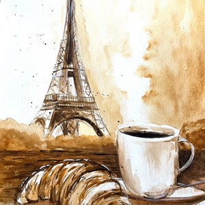 K&ouml;nnte beinhalten: Ein Aquarellbild eines Croissants, einer Tasse Kaffee und dem Eiffelturm im Hintergrund. Das Bild ist in Braun- und Wei&szlig;t&ouml;nen gehalten.