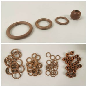 May include: A collection of wooden rings and beads in various sizes. The rings are brown and the beads are a darker brown. There are 20 beads and 15 rings.