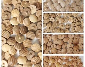 May include: A close-up view of a large quantity of wooden buttons in various shades of brown. The buttons have a smooth, rounded surface and a small hole in the center. Some buttons have a grooved pattern on the surface.