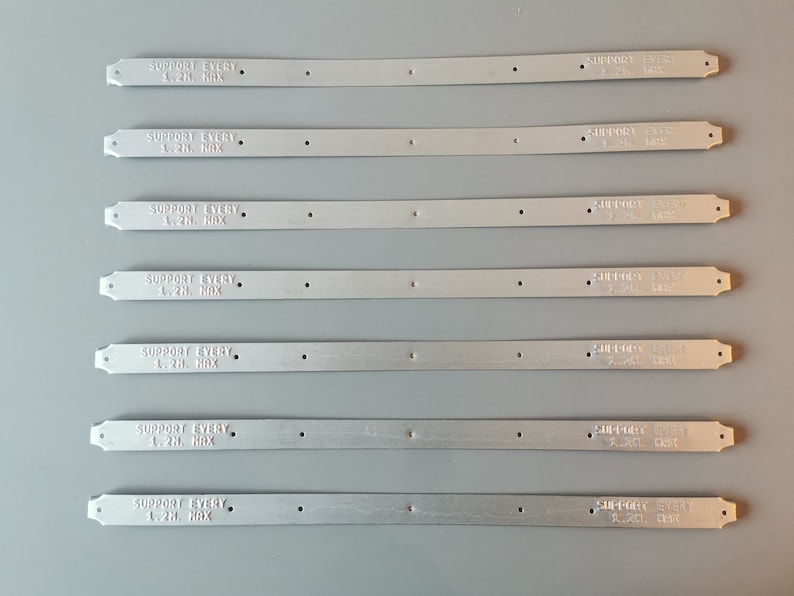 May include: Seven silver metal strips with the text "SUPPORT EVERY 1.2H. MAX" printed on each strip.