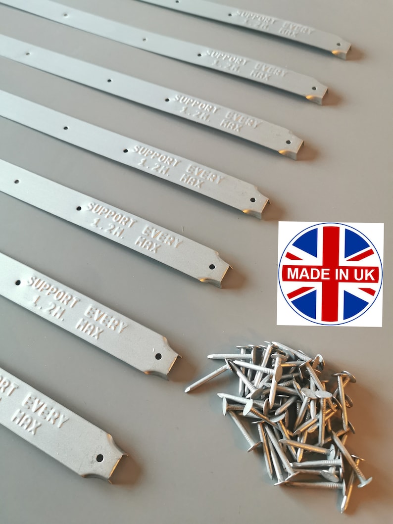 May include: A set of six silver metal strips with the text "SUPPORT EVERY 1.2M MAX" printed on each strip. The strips are designed to be used as supports for a shelf or other structure. A pile of silver nails is also included in the image.