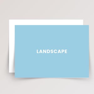 May include: A rectangular light blue card with the word LANDSCAPE printed in white capital letters in the center. The card is positioned in front of a plain white rectangular card, creating a layered effect with clean edges and a flat design.