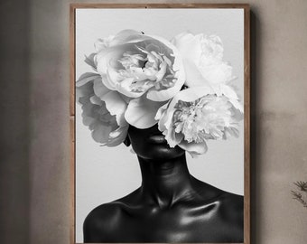 May include: Black and white photo of a person with large white flowers covering their face. The person is looking directly at the camera. The background is a light gray.