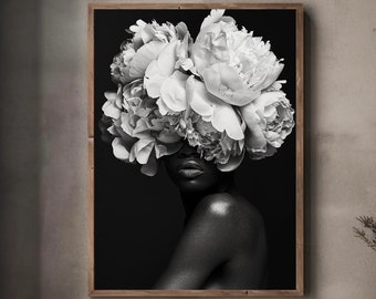 May include: Black and white photograph of a person with a bouquet of white flowers covering their face. The person is looking to the side and has a bare shoulder. The background is black.
