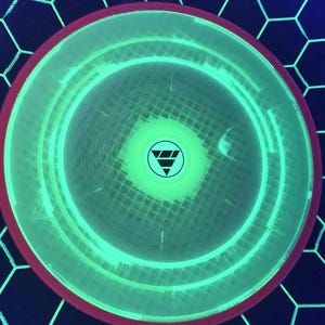 May include: A circular disc with a vibrant neon green glowing center and a dark red outer rim. The surface features a grid pattern and a central circular logo containing a downward-pointing triangle composed of three horizontal bars.