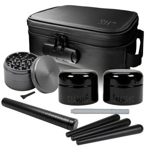 May include: A black, lockable storage case with a handle, containing a grinder, two black jars with "Stashic" text, a black tube, and other accessories. The case has the initials "SH" on the top.