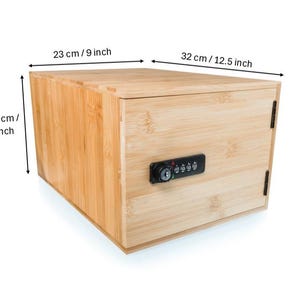 May include: A rectangular wooden box with a combination lock. The box is made of light-colored wood and measures 9 inches wide, 12.5 inches long, and 7 inches high. The lock is black and has a series of number dials.