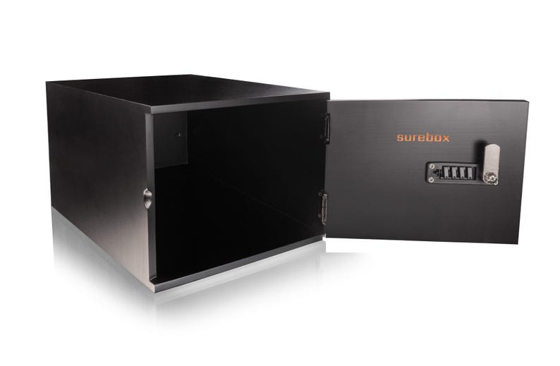 May include: A black, rectangular safe with the door open, revealing an empty interior. The open door displays the word "surebox" in orange, along with a combination lock and a silver handle. The safe is designed to secure valuables.