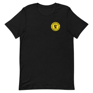 May include: Black t-shirt with a yellow circle logo featuring a red bird and the text "Liverpool Football Club 1892"