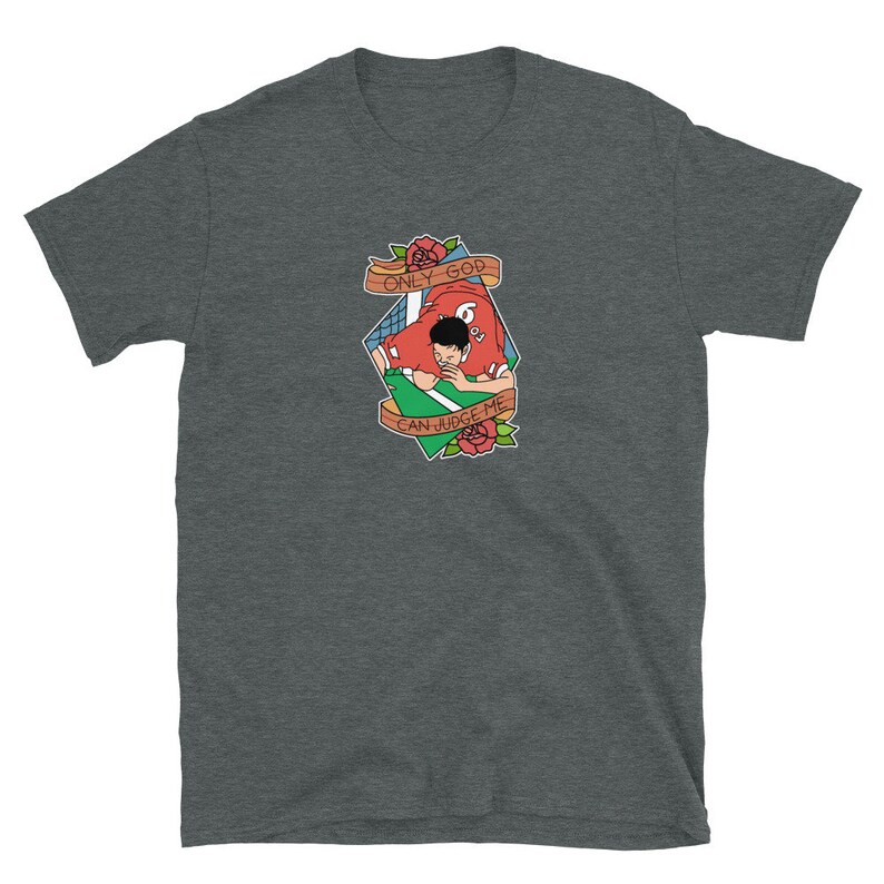 May include: A dark heather grey t-shirt with a cartoon illustration of a person in a red jersey with the text "ONLY GOD CAN JUDGE ME" in a banner above them.